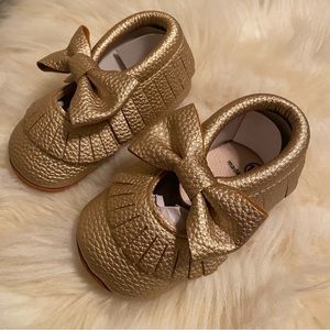 Little girl gold moccasins.
